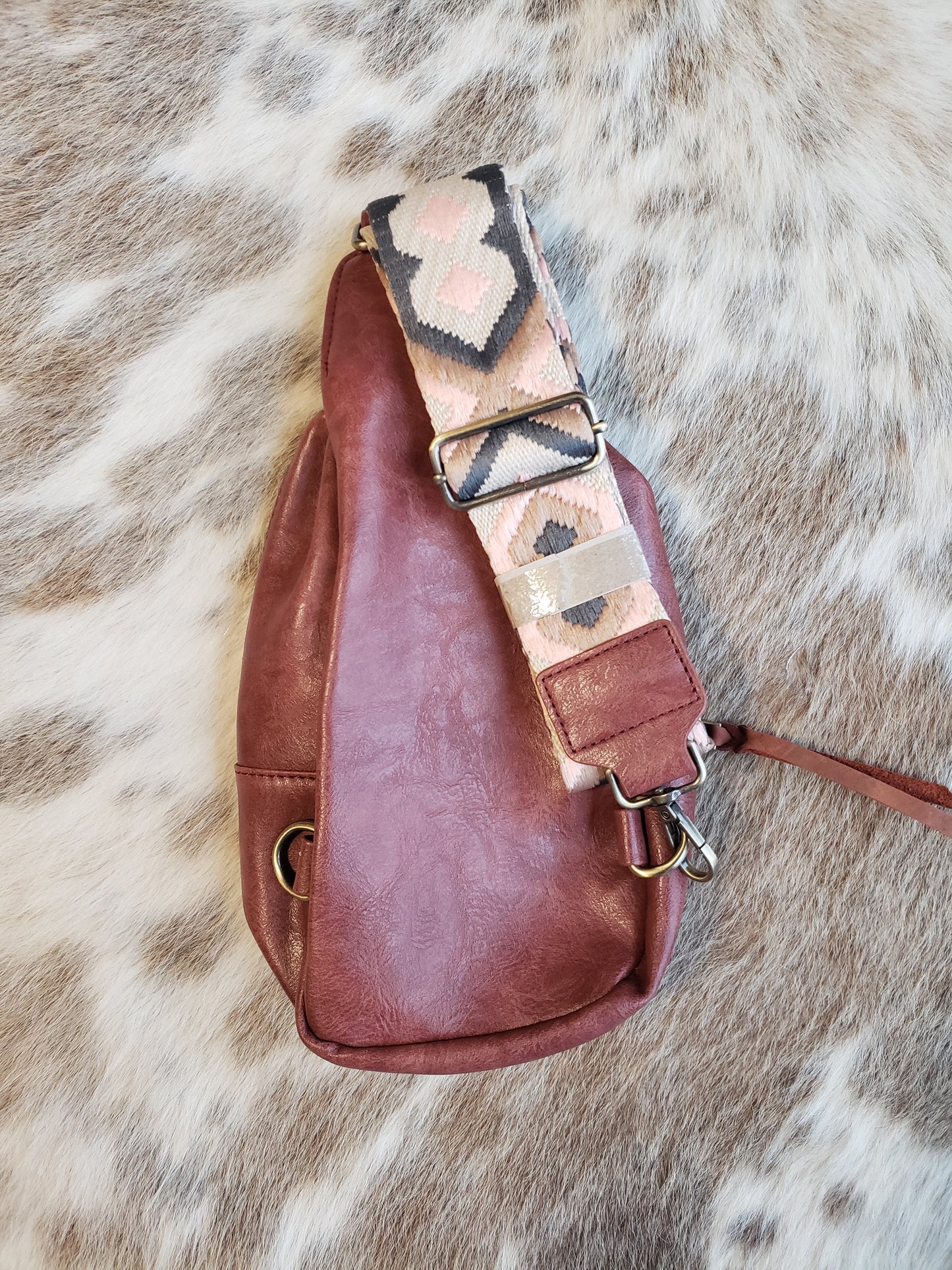 Small mahogany sling bag with tooled leather patch and fabric inlay